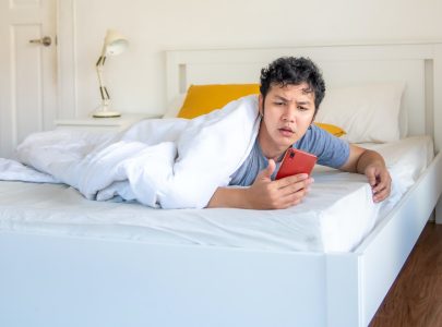 man in bed looking at their phone
